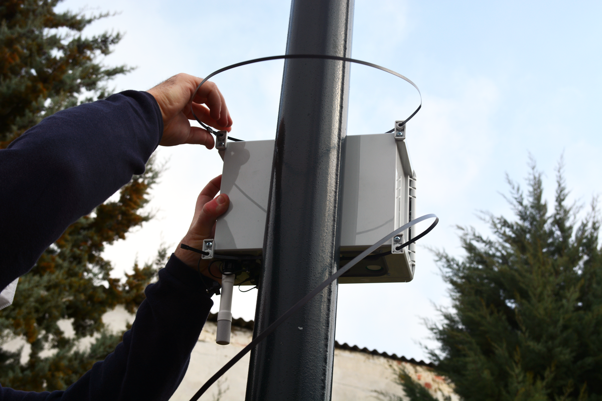 Fastening the metal cable ties to a lamppost